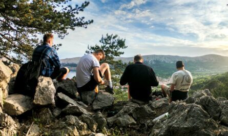 Four friends resting during a scenic hike in Jezerane, Croatia, surrounded by nature.